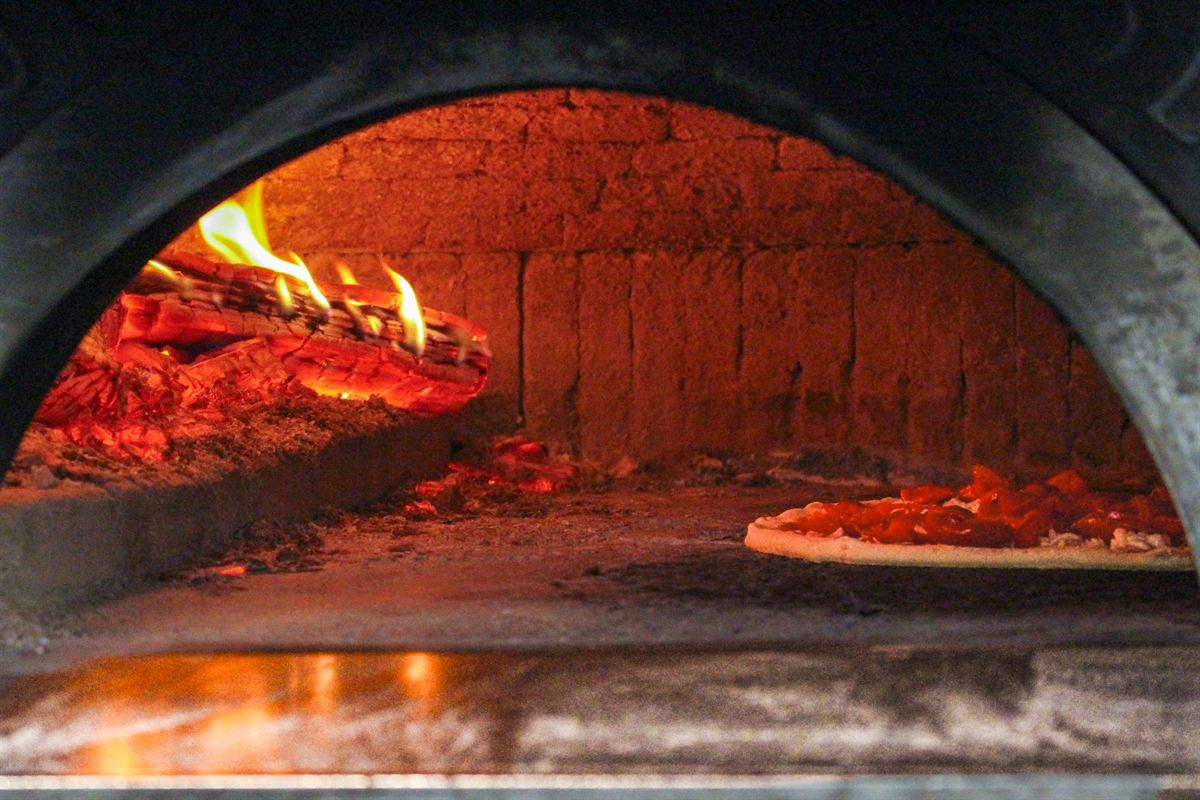 Pizza baking in the wood-fired oven
